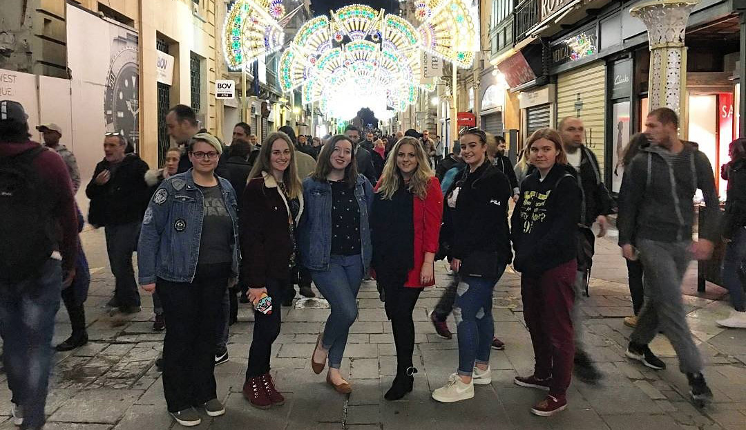 Group of students in Malta under street light decorations