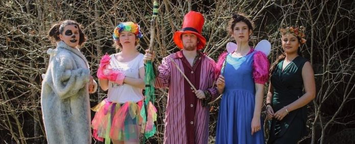 five young students in fancy dress in the forest